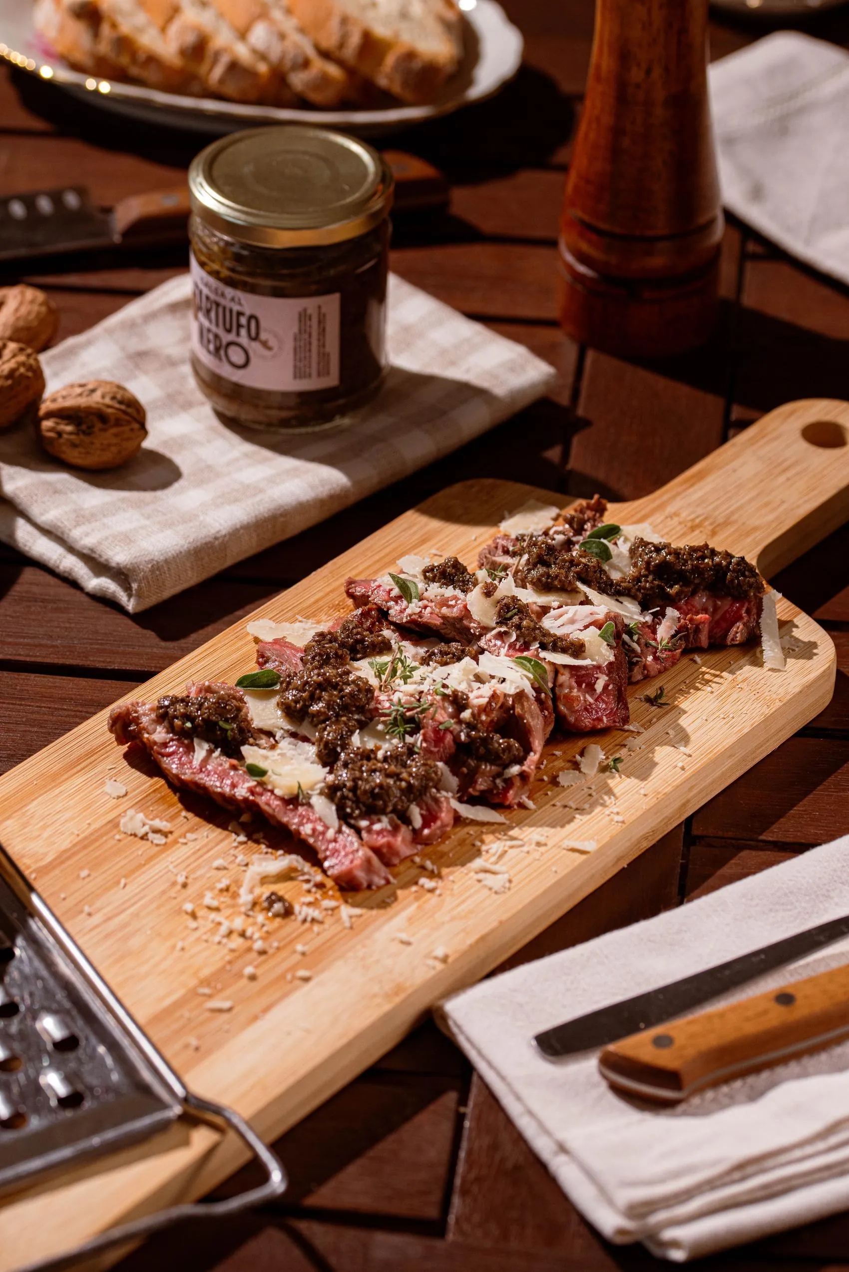 Tagliata con salsa al tartufo nero Alvitius, parmigiano e noci, tavola in legno